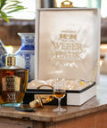 Cachaça Extra Premium Weber Haus XII Anos servida pura, ideal para harmonização com sobremesas sofisticadas. Ao fundo, embalagem da mesma.